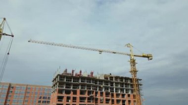 Tower lifting cranes at high residential apartment buildings construction site. Real estate development.