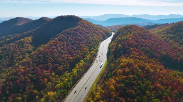 ノースカロライナ州のI 40高速道路ルートの上から見ると 黄色の秋の森と高速移動トラックや車でアパラチア山脈を通ってアシュビルにつながります 州間輸送の概念 — ストック動画