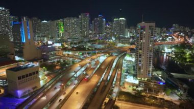 ABD ulaşım altyapısının üstünden bak. Miami City, Florida 'da gece hızlı giden araba ve kamyonlarla Amerikan otoyolu kavşağının hava görüntüsü..