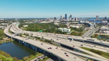 Jacksonville şehrinin hava manzarası. Yüksek ofis binaları ve hızlı araba ve kamyonlarla Amerikan otoyolu kavşağı. ABD ulaşım altyapısının üstünden görüntüle.