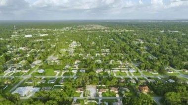 Florida 'nın sakin yerleşim bölgesinde yeşil palmiye ağaçları arasında özel evleri olan küçük bir Amerikan banliyö manzarası..