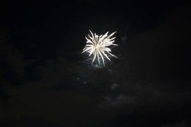 Aerial view of bright fireworks exploding with colorful lights against dark night sky on US Independence day holiday.