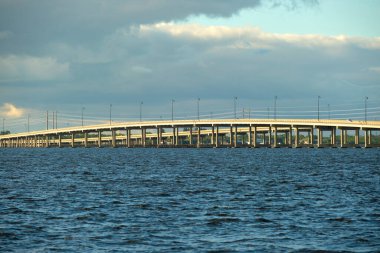 Barron Collier Bridge and Gilchrist Bridge in Florida with moving traffic. Transportation infrastructure in Charlotte County connecting Punta Gorda and Port Charlotte over Peace River.