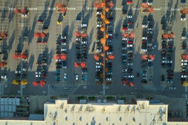Otoparkta park yeri ve park yerleri için çizgiler ve işaretler olan bir sürü park etmiş aracın olduğu Amerikan marketinin manzarası. Bir alışveriş merkezinin önünde araçlar için yer.