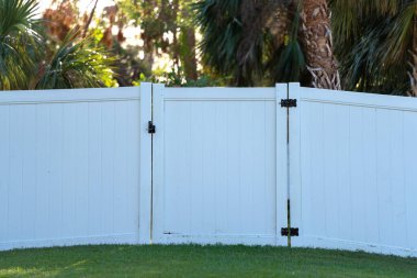 White plastic fence for back yard protection and privacy.