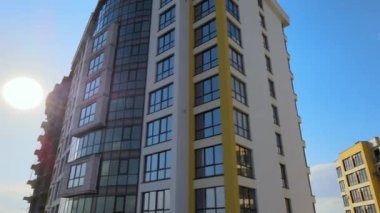 High residential apartment building with monolithic frame and glass windows under construction. Real estate development.