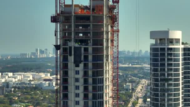 アメリカの都市部の住宅開発の新しい建設現場 フロリダ州マイアミの産業用タワーリフティングクレーン 米国における住宅成長の概念 — ストック動画