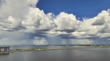 Stormy clouds forming from evaporating humidity of ocean water before thunderstorm over traffic bridge connecting Punta Gorda and Port Charlotte over Peace River. Bad weather conditions for driving.