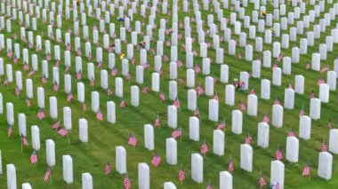 Yeşil çimlerin üzerinde beyaz mezar taşları olan Amerikan ulusal mezarlığı. Anma Günü konsepti.