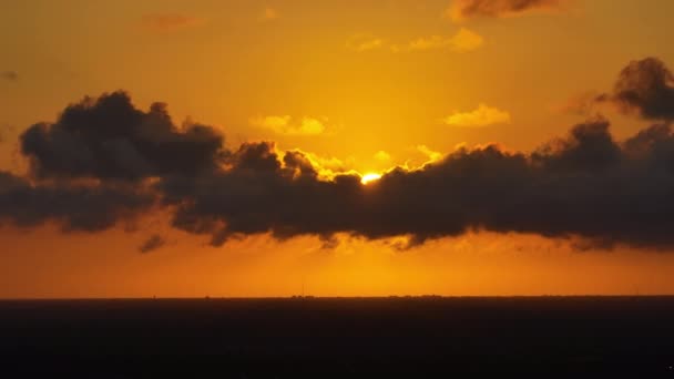 鮮やかなオレンジ色と黄色の雲の後ろに夕日と明るい夕日 — ストック動画