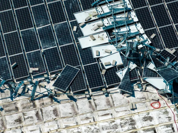 ハリケーンイアン風によって破壊された太陽光発電パネルを破壊緑の生態系電気を生産するための産業用建物の屋根に取り付けられました 自然災害の結果 — ストック写真