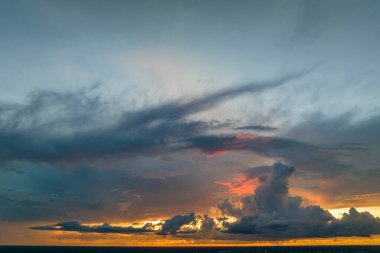 White fluffy cumulonimbus clouds forming before thunderstorm on evening sky. Changing stormy cloudscape weather at sunset.