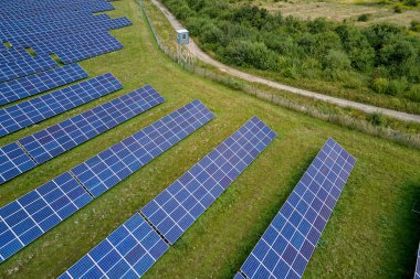 Temiz elektrik enerjisi üretmek için sıra sıra güneş fotovoltaik panelleri olan sürdürülebilir büyük elektrik santralinin havadan görünüşü. Sıfır emisyonlu yenilenebilir elektrik kavramı.