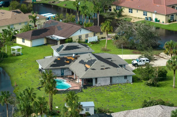 stock image Destroyed by hurricane strong wind private house with damaged rooftop and swimming pool lanai enclosure in Florida residential area. Natural disaster and its consequences.