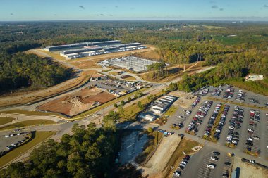 Birçok ortak araba endüstriyel fabrika binasının önündeki büyük otoparka park etti. Üretim ve küresel sanayi kavramı.