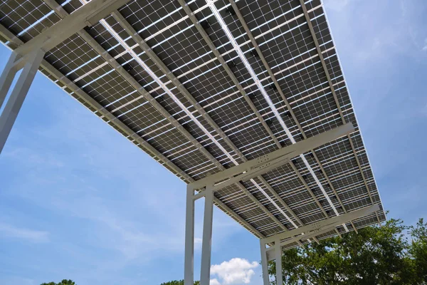 Solar panels installed over parking lot canopy shade for parked cars for effective generation of clean energy.