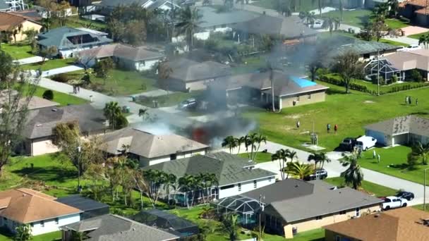 从上面看着火的私人房屋和消防员扑灭大火后的短路引起的屋顶被飓风伊恩破坏 佛罗里达州郊区的家庭灾难 — 图库视频影像
