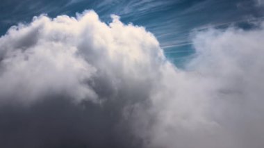 Dünya 'nın yüksek irtifasında, yağmur fırtınasından önce oluşan kabarık kümülüs bulutlarıyla kaplı uçak penceresinden hava görüntüsü.