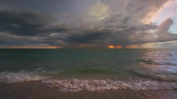 砂のビーチで粉砕夕方の海の波の上に雷や雷と雷雨暗い雲 夕日の美しい海 — ストック動画