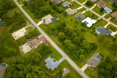 Aerial landscape view of suburban private houses between green palm trees in Florida quiet rural area.