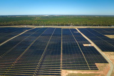 Temiz elektrik enerjisi üretmek için birçok sıra güneş fotovoltaik paneli bulunan sürdürülebilir büyük elektrik santralinin havadan görünüşü. Sıfır emisyon kavramı ile yenilenebilir elektrik.
