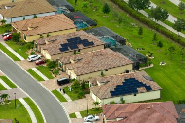 Florida 'nın kapalı banliyö bölgesindeki çatılarda güneş panelleri olan aile evlerinin hava görüntüsü. Amerikan banliyölerinde gayrimenkul geliştirme.