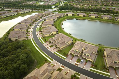 Florida 'da göl suyu olan kapalı yaşam kulüplerinin hava manzarası. Amerikan banliyölerinde emlak gelişimine örnek olarak aile evleri.