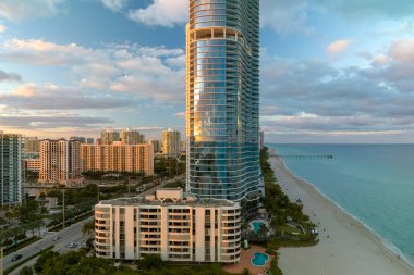 Günbatımında Sunny Isles Sahili 'nde Atlantik Okyanusu kıyısındaki kumlu deniz kıyısında pahalı oteller ve apartmanlar. Güney Florida 'daki Amerikan turizm altyapısı.