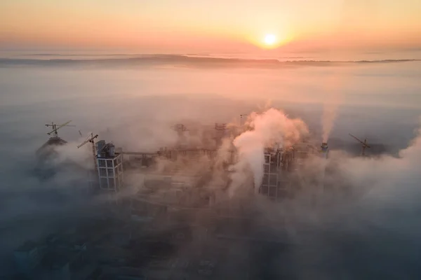 雾天早晨 工业园区内具有高混凝土厂房结构和塔式起重机的水泥厂的空中景观 制造业和全球工业概念 — 图库照片