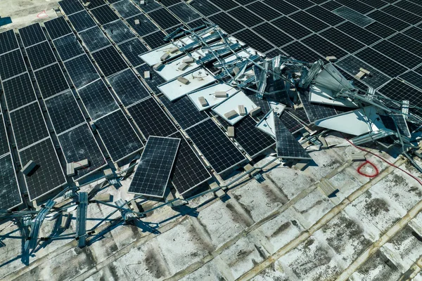 緑の生態系電気を生成するための産業用建物の屋根に取り付けハリケーン風力太陽光発電パネルによって損傷の空中ビュー 自然災害の結果 — ストック写真