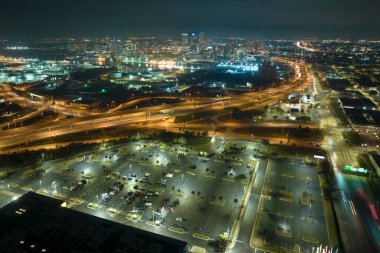 Gece yarısı bir süpermarketin önünde parketmiş bir otoparktaki park halindeki birçok aracın görüntüsü. Alışveriş merkezinin önünde araçlar için yer.