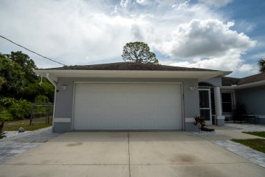 Wide garage double door and concrete driveway of new modern american house.