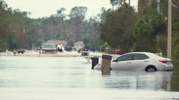 ハリケーン イアンの上陸後 フロリダの住宅街の水の下で浸水した車で浸水した町の通り 自然災害の結果 — ストック動画