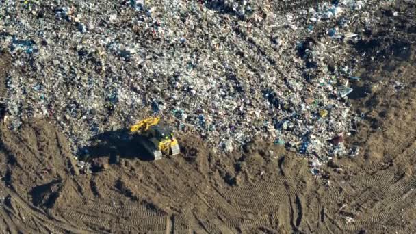 用推土机拖拉机把垃圾埋在地下的大型垃圾填埋场 现代消费主义对环境的有害影响 — 图库视频影像