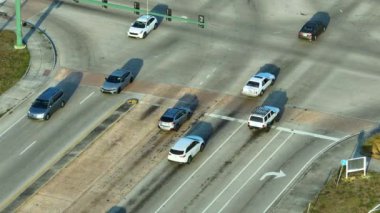 Trafik ışıklarıyla kesişen geniş, çoklu şeritli bir yoldan görüntüyü al. ABD 'de şehir ulaşımı. Amerikan şehir trafiği.