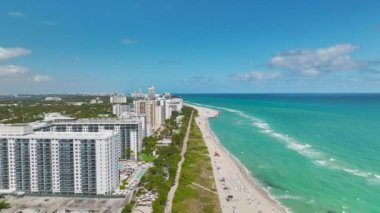 Sıcak Florida güneşinde dinlenen turistlerle birlikte güney sahilinin kumlu yüzeyi. Yüksek lüks otelleri ve apartmanları olan Miami Beach City. Güney Amerika 'da turizm altyapısı.