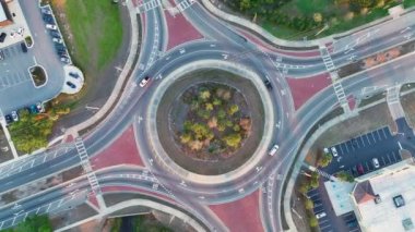 American City caddesindeki kavşağın yukarısından hareket eden trafik arabalarının görüntüsü. Kentsel dairesel ulaşım kavşağı.