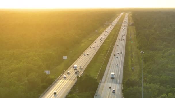 日没の速い移動トラフィックを持つ忙しいアメリカの高速道路の空中ビュー 州間輸送の概念 — ストック動画