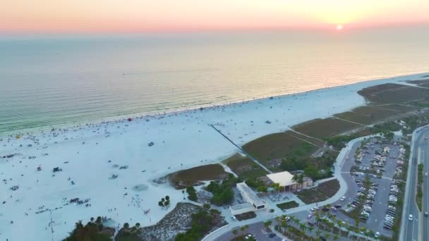 サラソータ 米国の有名なシエスタキービーチの前に観光客の車の駐車場の空中ビュー 日没で暖かいフロリダの人気の休暇スポット — ストック動画