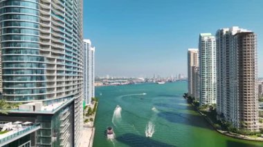 Miami Brickell, Florida, ABD. Şehir merkezindeki cam gökdelen binaların arasından Miami Nehri 'ndeki lüks yatların manzarası. Güneşli bir günde iş dünyasının finans bölgesiyle Amerikan megapolis 'i.