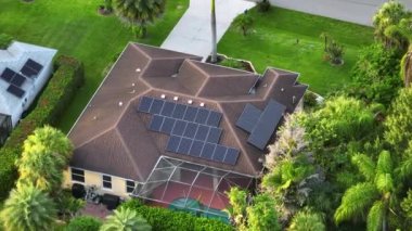 Banliyö bölgesinde temiz ekolojik elektrik üretimi için güneş panelleriyle kaplı Amerika 'daki sıradan bir ev. Enerji tasarrufu için özerk eve yatırım yapma kavramı.