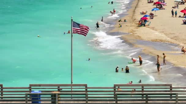 アメリカ合衆国フロリダ州ヴェネツィアの釣り桟橋で振るアメリカの国旗の航空眺め ガルフウォーターで泳ぐ休暇を楽しみ リラックス — ストック動画