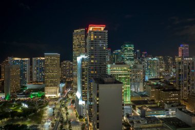 Florida, ABD 'de Miami Brickell şehir merkezinin hava görüntüsü. Günümüz Amerika 'sında arabaları ve metro trafiği ile aydınlık gökdelen binaları ve caddeleri.