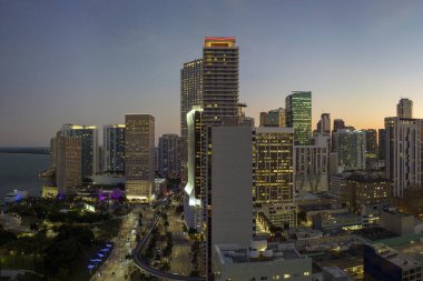 Florida, ABD 'de Miami Brickell şehir merkezinin hava görüntüsü. Günümüz Amerika 'sında arabaları ve metro trafiği ile aydınlık gökdelen binaları ve caddeleri.