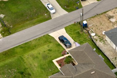 Tipik modern Amerikan özel evinin çatısı asfalt kiremitlerle ve bahçedeki yeşil çimlerle kaplı..