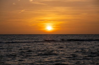 Okyanus batımı. Büyük beyaz güneş dramatik parlak gökyüzü arka planında, yumuşak akşam ufku denizin üstünde karanlık su üzerinde..