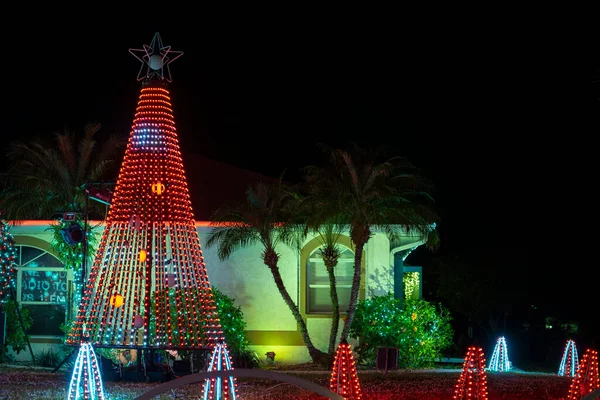 Front yard with brightly illuminated christmas decorations. Outside decor of florida family home for winter holidays.