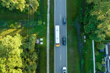 Klasik Amerikan sarı okul otobüsünün kırsal kesimde sabah erken saatlerde şarkı söylemek için araba sürüşünün en iyi görüntüsü. ABD 'de toplu taşıma.