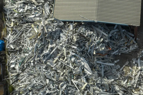 Aerial view of large pile of scrap aluminum metal from broken houses after hurricane Ian swept through Florida. Recycle of broken parts of mobile homes.