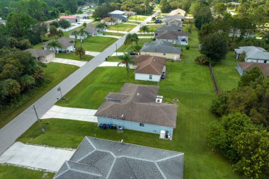 Florida 'nın sakin yerleşim bölgesinde yeşil palmiye ağaçları arasında özel evleri olan küçük bir Amerikan banliyö manzarası..
